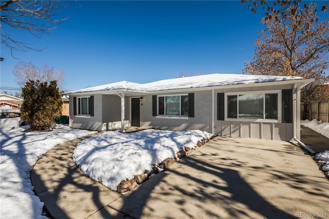 ranch-style house featuring brick siding and fence