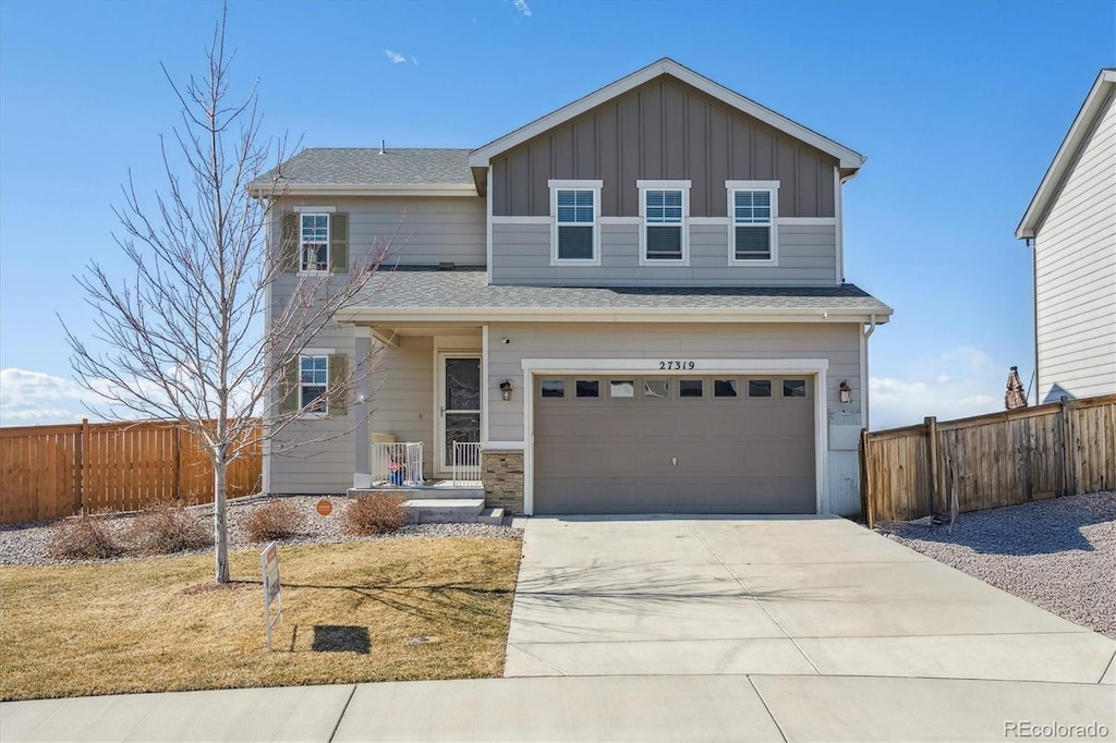 view of front of home featuring board and batten siding, concrete driveway, fence, and an attached garage