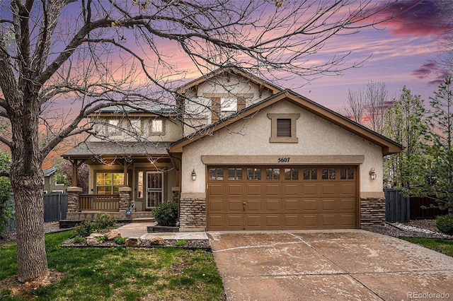 5607 S Gray St, Littleton, CO 80123 - view of front of house with a porch, a garage, concrete driveway, and stucco siding