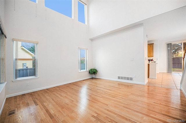 5607 S Gray St, Littleton, CO 80123 - unfurnished living room featuring visible vents, light wood-style flooring, and a healthy amount of sunlight