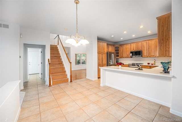 5607 S Gray St, Littleton, CO 80123 - kitchen featuring brown cabinetry, an inviting chandelier, stainless steel appliances, recessed lighting, and light tile patterned flooring