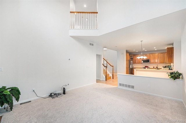 5607 S Gray St, Littleton, CO 80123 - unfurnished living room featuring light colored carpet, stairs, and visible vents