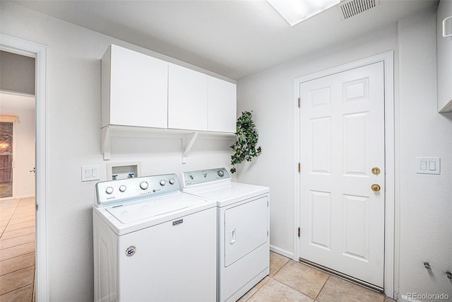 5607 S Gray St, Littleton, CO 80123 - washroom featuring light tile patterned floors, visible vents, cabinet space, and washer and dryer
