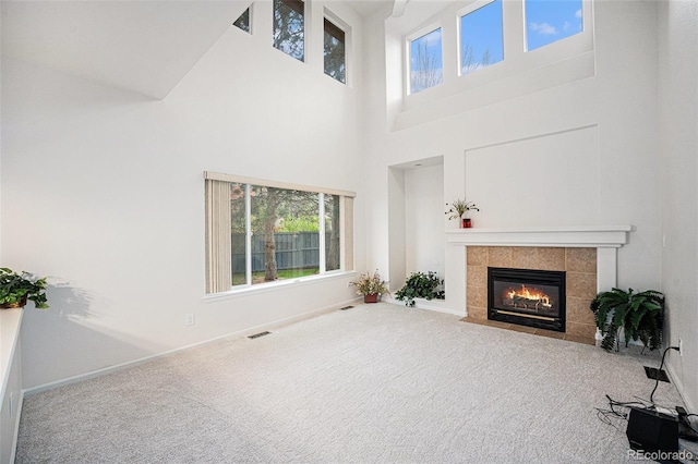 5607 S Gray St, Littleton, CO 80123 - living room featuring a healthy amount of sunlight, a high ceiling, a fireplace, and carpet flooring