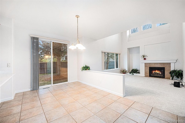 5607 S Gray St, Littleton, CO 80123 - unfurnished living room with a high ceiling, tile patterned floors, a wealth of natural light, and a tile fireplace