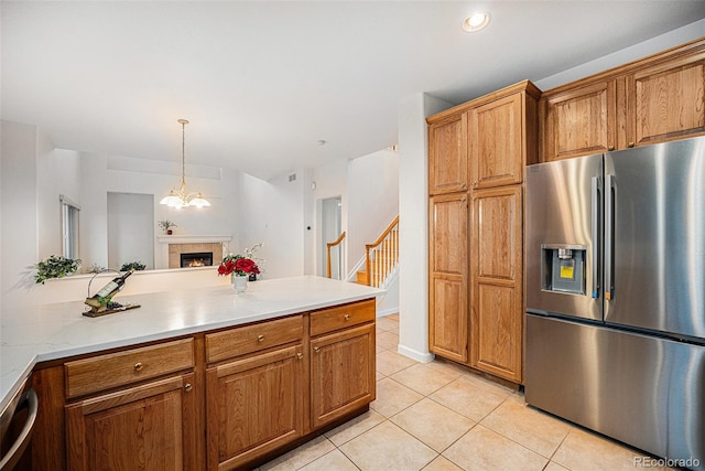 5607 S Gray St, Littleton, CO 80123 - kitchen with brown cabinets, light tile patterned flooring, stainless steel fridge with ice dispenser, and light countertops