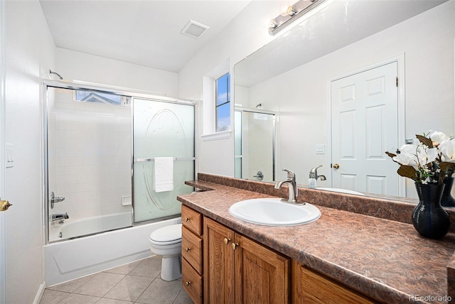 5607 S Gray St, Littleton, CO 80123 - full bath featuring tile patterned flooring, vanity, toilet, visible vents, and bath / shower combo with glass door