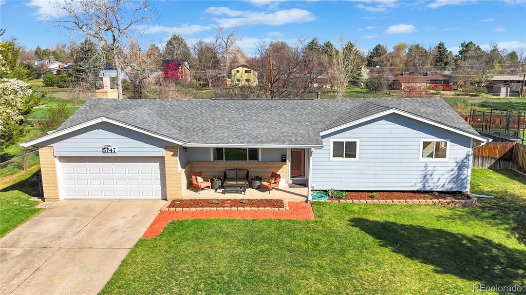 5747 W Elmhurst Ave, Littleton, CO 80128 - ranch-style home with concrete driveway, fence, brick siding, an attached garage, and a front yard
