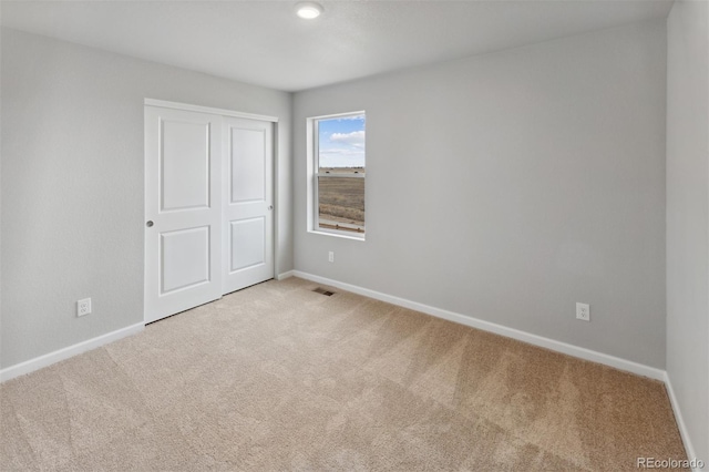 unfurnished bedroom with carpet, visible vents, and baseboards