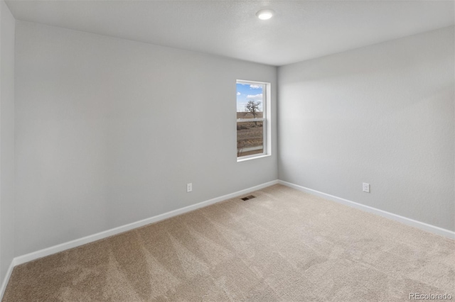 unfurnished room featuring baseboards, visible vents, and carpet flooring