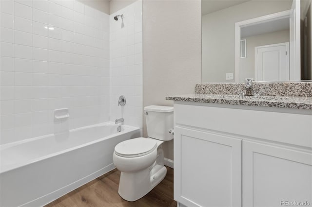 bathroom with toilet, washtub / shower combination, wood finished floors, and vanity