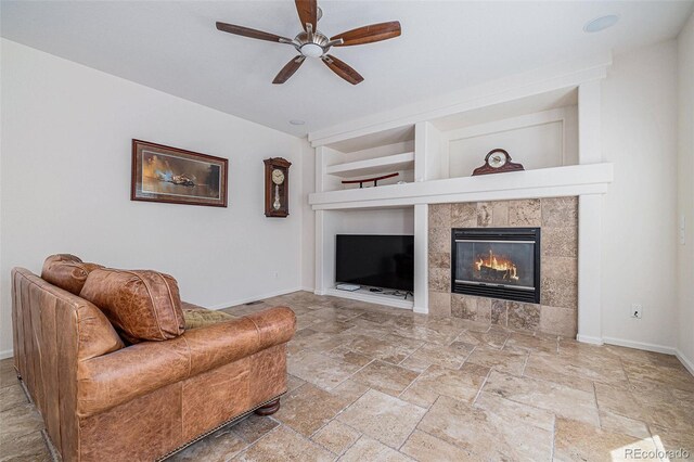 11973 Song Bird Hills St, Parker, CO 80138 - living room with built in features, ceiling fan, stone tile flooring, and a fireplace