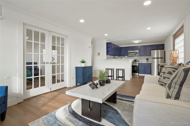 living room featuring french doors, ornamental molding, and light hardwood / wood-style flooring