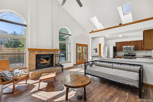 6980 Native Cir, Colorado Springs, CO 80919 - living area with high vaulted ceiling, hardwood / wood-style floors, a skylight, a fireplace, and ceiling fan