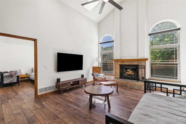 6980 Native Cir, Colorado Springs, CO 80919 - living room featuring high vaulted ceiling, a ceiling fan, hardwood / wood-style flooring, plenty of natural light, and a fireplace with raised hearth