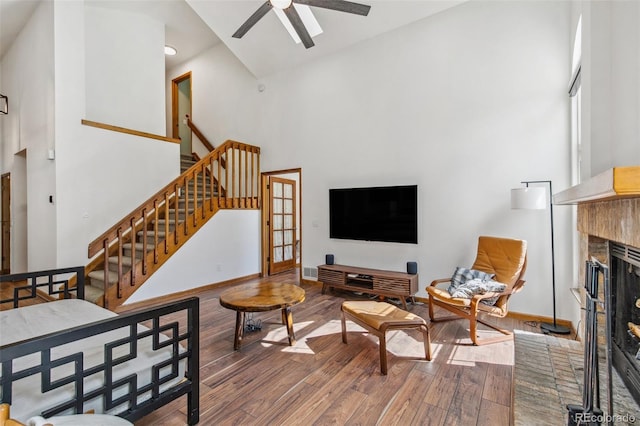 6980 Native Cir, Colorado Springs, CO 80919 - living area featuring high vaulted ceiling, a brick fireplace, wood finished floors, stairs, and ceiling fan
