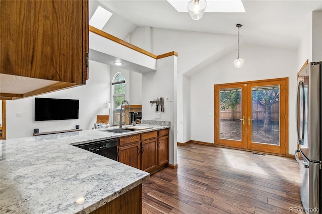 6980 Native Cir, Colorado Springs, CO 80919 - kitchen with a sink, vaulted ceiling, freestanding refrigerator, dishwasher, and dark wood-type flooring