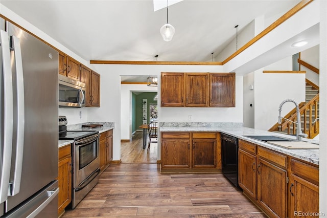 6980 Native Cir, Colorado Springs, CO 80919 - kitchen with stainless steel appliances, a sink, dark wood finished floors, and brown cabinets