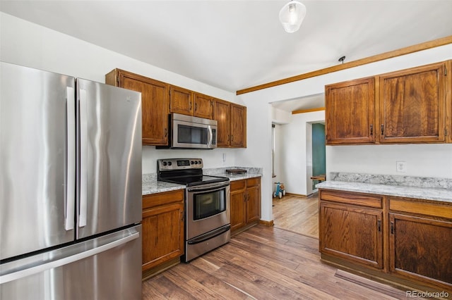 6980 Native Cir, Colorado Springs, CO 80919 - kitchen featuring stainless steel appliances, dark wood-type flooring, brown cabinets, and baseboards
