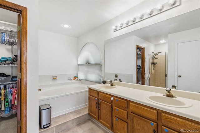 6980 Native Cir, Colorado Springs, CO 80919 - bathroom featuring a spacious closet, a garden tub, a stall shower, and tile patterned flooring
