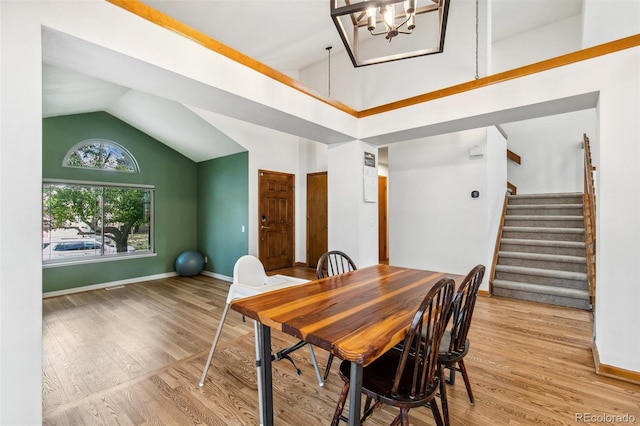 6980 Native Cir, Colorado Springs, CO 80919 - dining area with a chandelier, wood finished floors, stairs, baseboards, and high vaulted ceiling