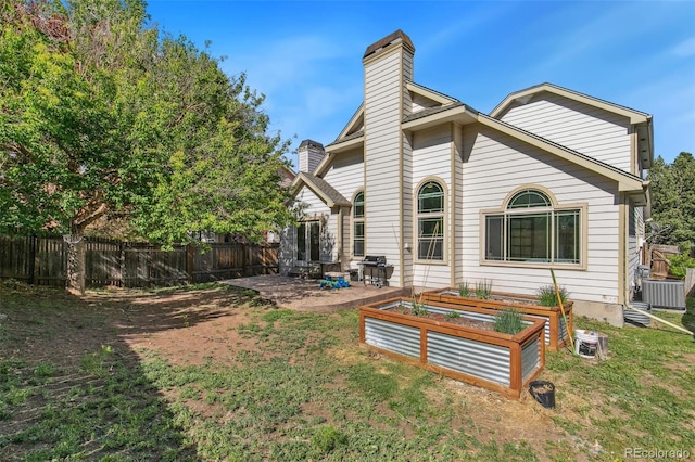 6980 Native Cir, Colorado Springs, CO 80919 - rear view of property featuring a chimney, a vegetable garden, and a patio area