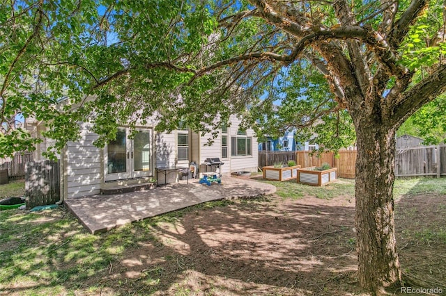 6980 Native Cir, Colorado Springs, CO 80919 - back of house featuring a patio, a fenced backyard, french doors, and a garden