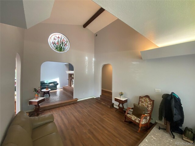 7079 Estes Dr, Arvada, CO 80004 - living area featuring arched walkways, high vaulted ceiling, wood finished floors, baseboards, and beamed ceiling