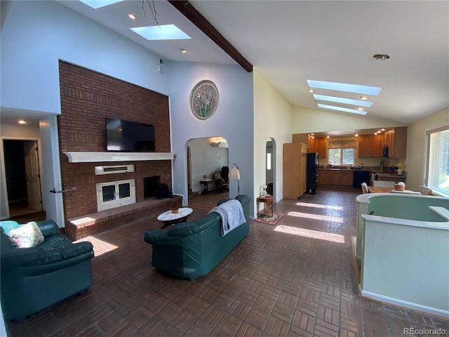 7079 Estes Dr, Arvada, CO 80004 - living area featuring a skylight, lofted ceiling, arched walkways, and a fireplace