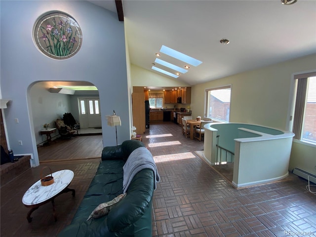 7079 Estes Dr, Arvada, CO 80004 - living area with arched walkways, healthy amount of natural light, a skylight, high vaulted ceiling, and recessed lighting