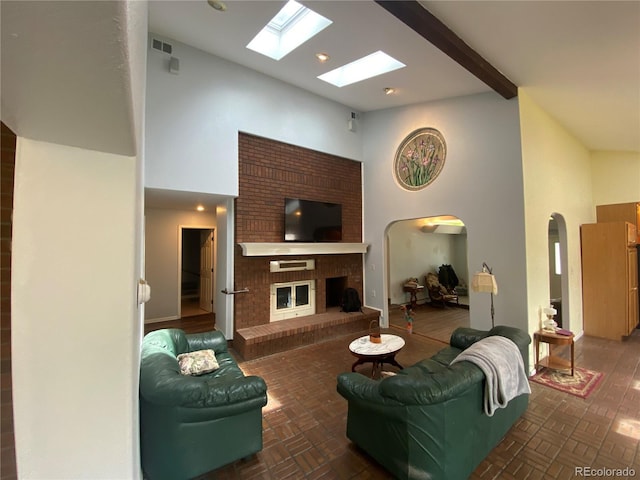 7079 Estes Dr, Arvada, CO 80004 - living area featuring a brick fireplace, a skylight, high vaulted ceiling, and arched walkways
