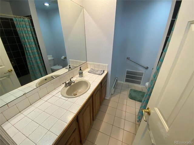 7079 Estes Dr, Arvada, CO 80004 - bathroom with toilet, tile patterned floors, vanity, and curtained shower