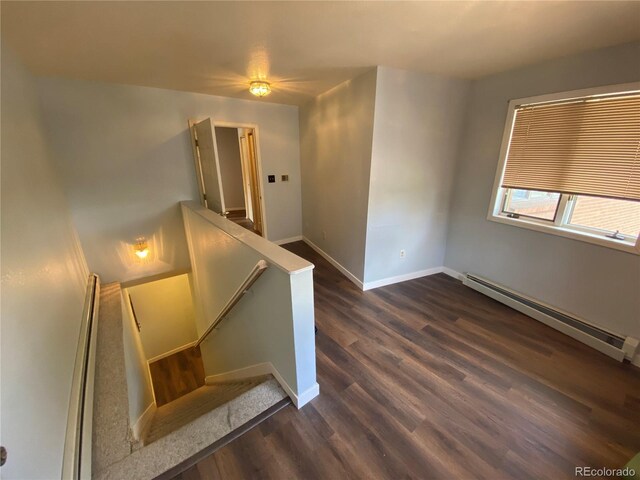 7079 Estes Dr, Arvada, CO 80004 - stairs with a baseboard heating unit, wood finished floors, and baseboards