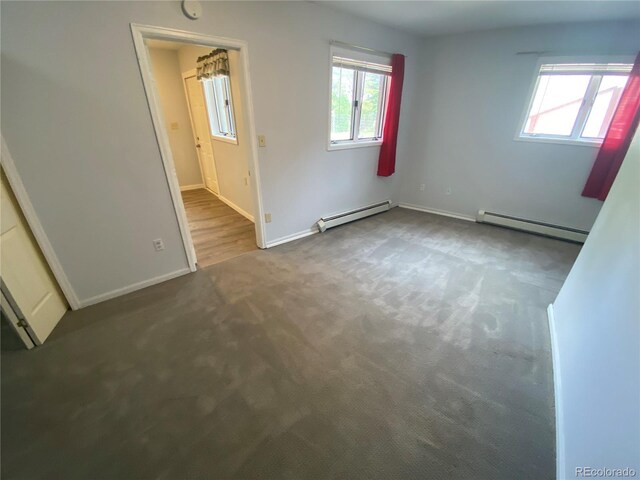 7079 Estes Dr, Arvada, CO 80004 - carpeted spare room featuring a baseboard heating unit, plenty of natural light, and baseboards