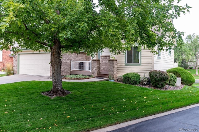 view of property hidden behind natural elements with a garage and a front yard