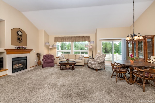 living room with carpet flooring, a tile fireplace, a notable chandelier, and vaulted ceiling