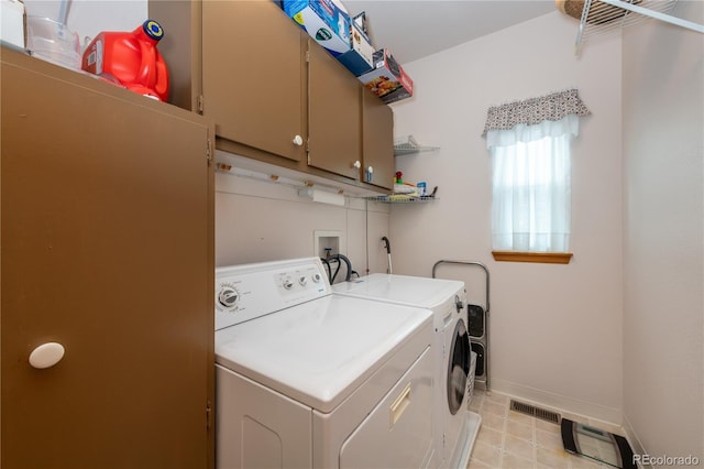 clothes washing area featuring cabinets and washer and dryer