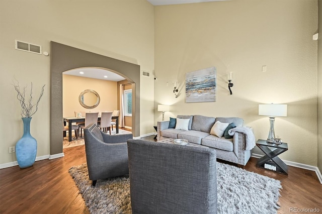15756 E Aberdeen Ave, Centennial, CO 80016 - living room featuring arched walkways, wood finished floors, and a high ceiling