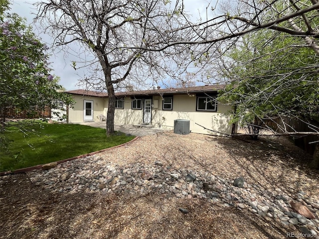 back of house with a lawn and cooling unit