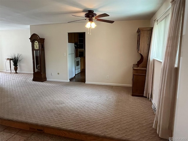 carpeted empty room featuring baseboards and ceiling fan
