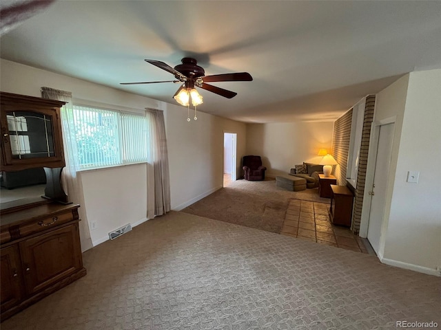 carpeted living room with baseboards, ceiling fan, and visible vents