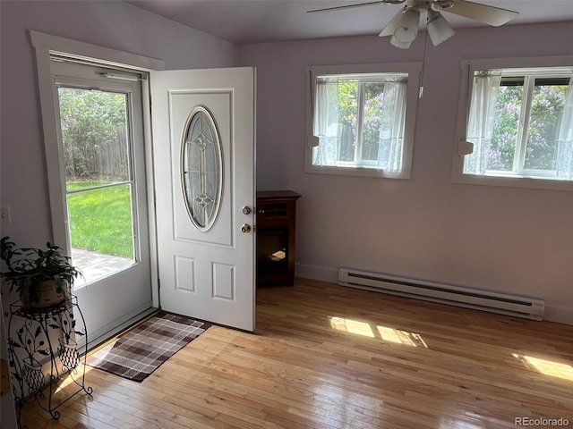 entrance foyer featuring a ceiling fan, a healthy amount of sunlight, light wood-style flooring, and a baseboard radiator