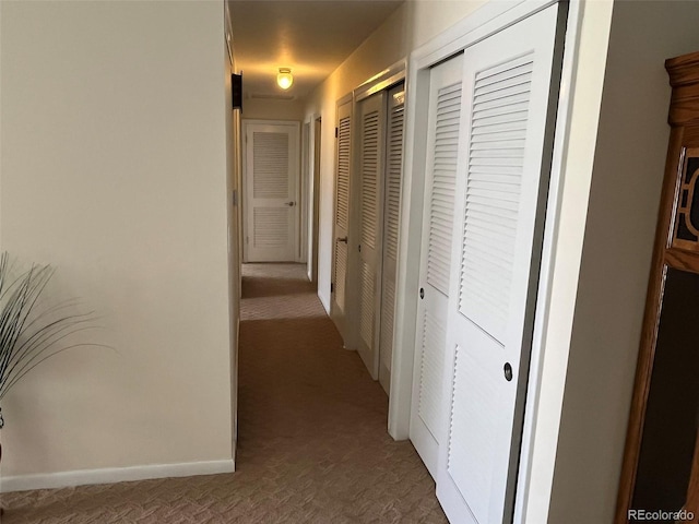 hall with carpet flooring and baseboards