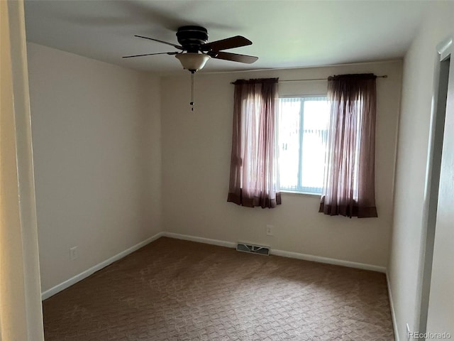 carpeted spare room featuring ceiling fan, visible vents, and baseboards
