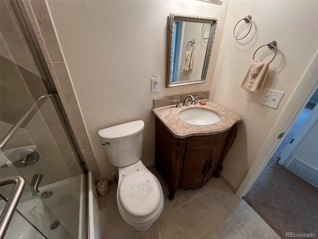 bathroom featuring vanity, toilet, tile patterned floors, and a stall shower