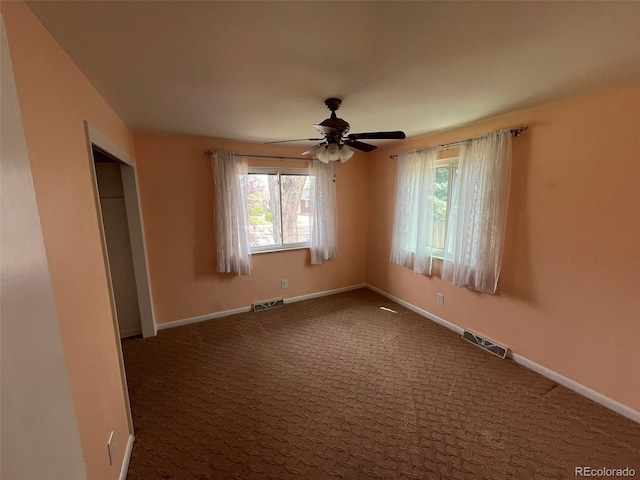 unfurnished room with a healthy amount of sunlight, a ceiling fan, and visible vents
