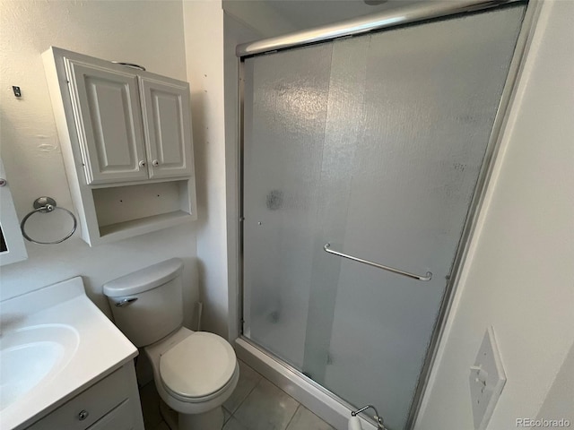 bathroom with vanity, tile patterned floors, a stall shower, and toilet