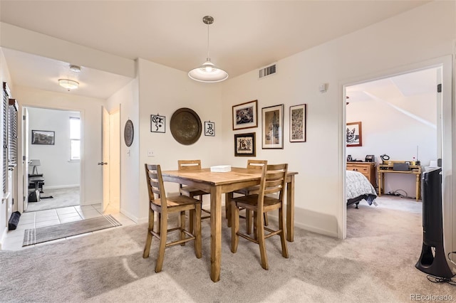 dining area featuring light carpet