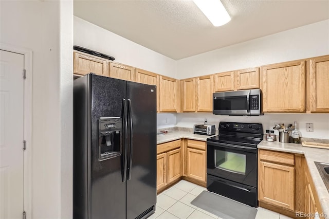 kitchen with light brown cabinets, light tile patterned floors, a textured ceiling, and black appliances