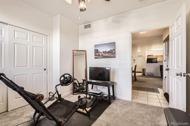 workout area with ceiling fan and light carpet